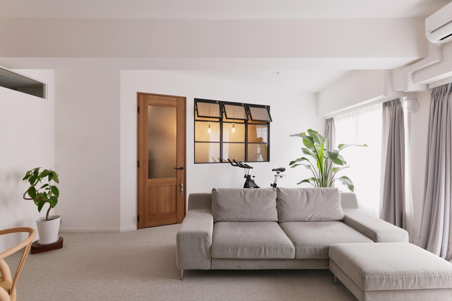 リビング横にあった書斎の間仕切りを思い切って斜めに。リビングスペースが拡大し、南側に面した２つの窓からの光がLDK全体に届くようになった。書斎の建具はこれから揃えていくアンティーク家具に馴染むチェリー色を採用。大きな室内窓で採光と風通しも確保。