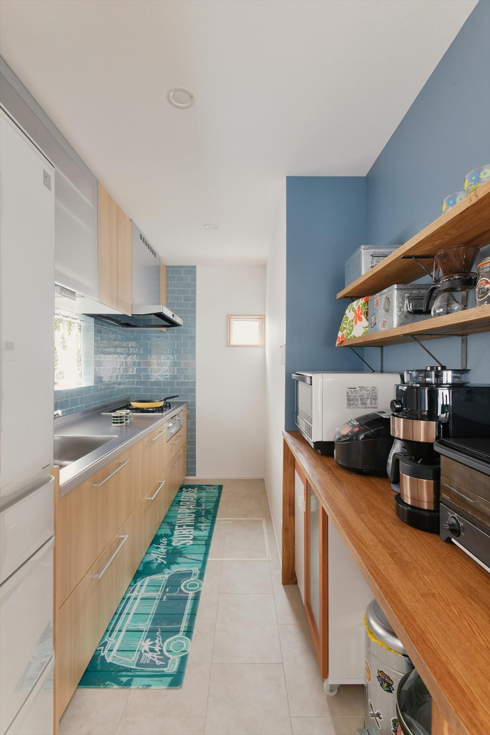 キッチンはクロスやタイルにOさんが好きなブルーを使い、料理を楽しめる空間に。背面には家電カウンターを備えた収納を造作。