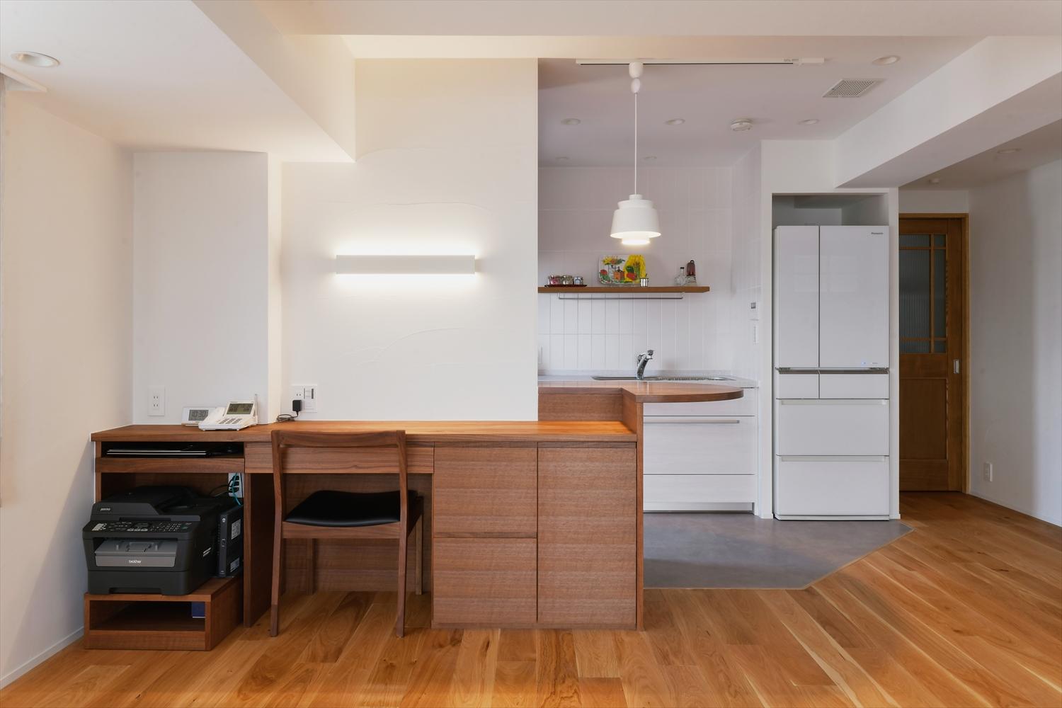 キッチンとダイニングの間には、収納、カウンターテーブル、ワークスペースを繋げた家具を設置。ウォルナットの色と質感が美しい、家具職人による造作家具がLDKの魅せ場に。