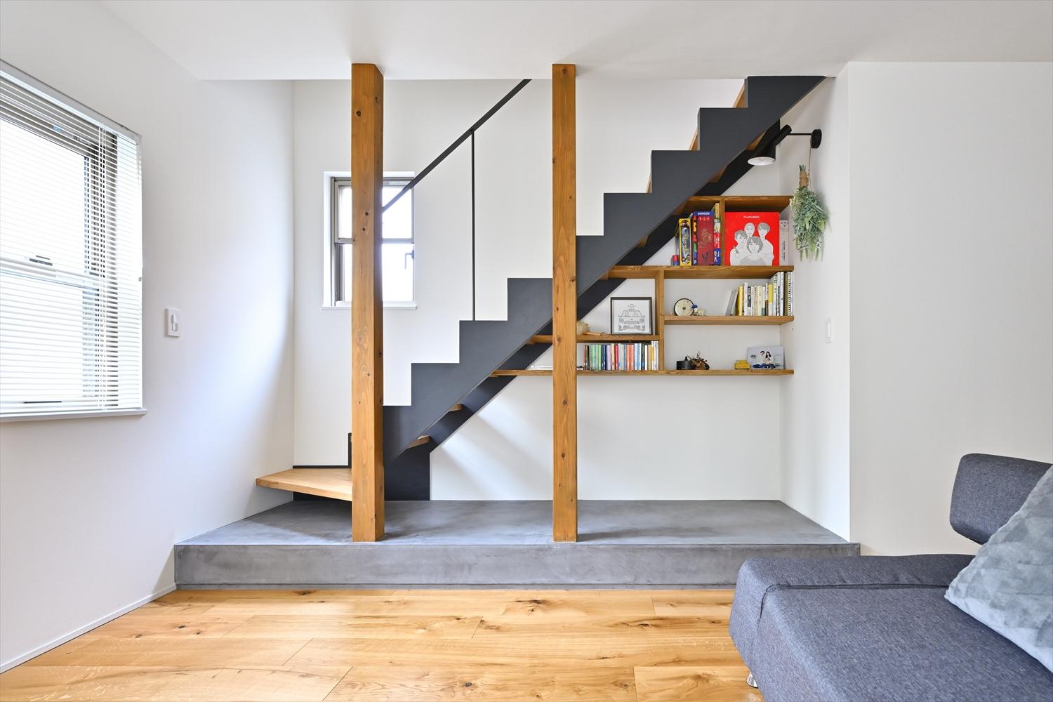 階段横の壁を撤去し、オープンにした階段のささらを黒く塗装。予算を抑えつつ、鉄骨階段のように仕上げた。階段下の空間に本棚を造作し、程よいこもり感のあるリーディングヌックに。