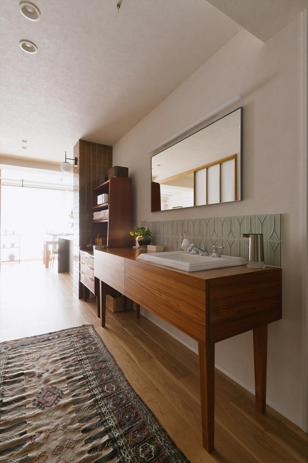 洗面台は脱衣所から出して、廊下に設置。廊下自体も広げたので、洗面をおいても窮屈感はない。お手持ちの家具と似た雰囲気に仕上げた造作洗面台はお住まいの見どころに。使い勝手と美しさを両立。