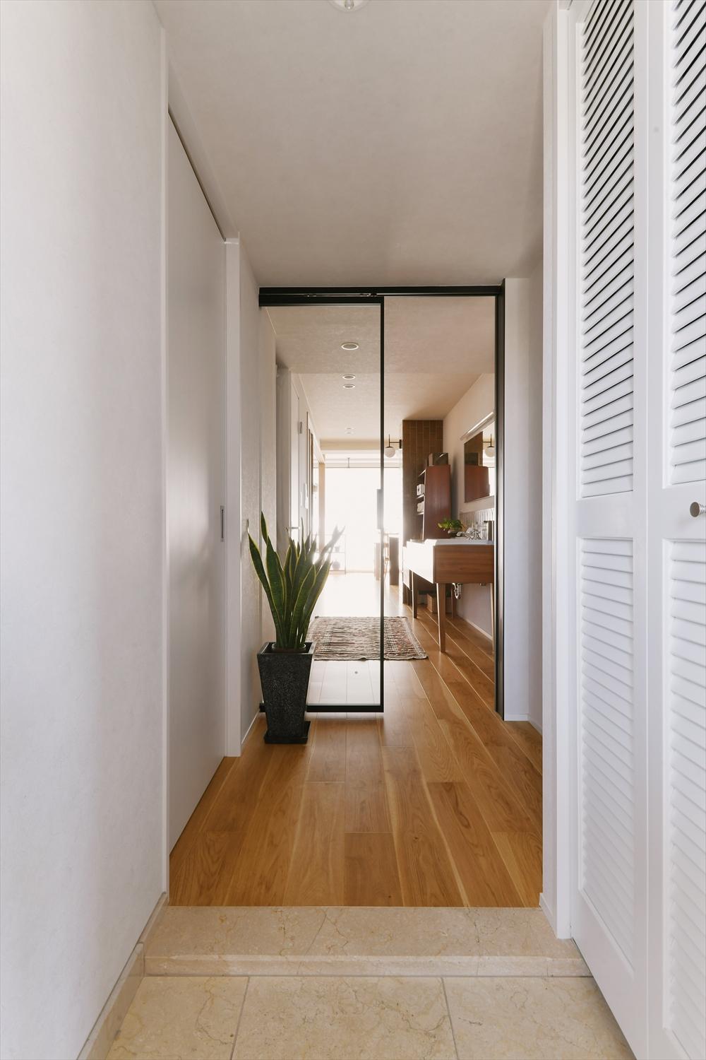 リビングドアはガラス戸を採用。玄関を開けると自慢の洗面台が見える。リビングのバルコニーからの光も廊下まで届き、暗かった玄関・廊下も明るくなった。