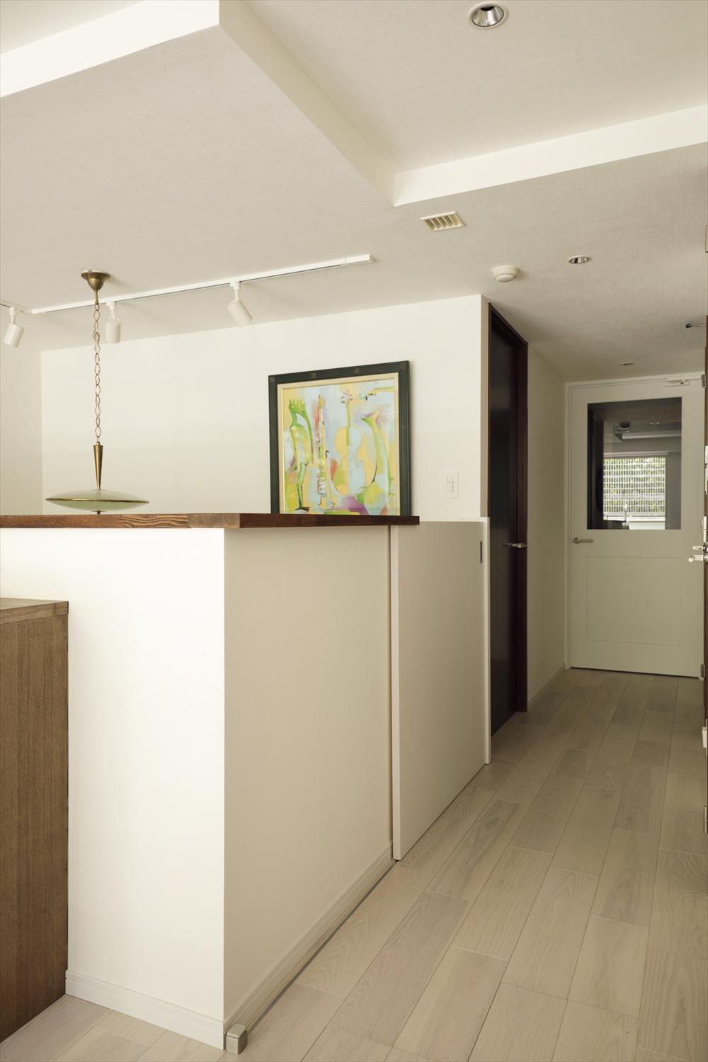 エアコンの冷気が下に逃げないよう、地階へ降りる階段入口に腰壁の高さに合わせた引き戸を設置。