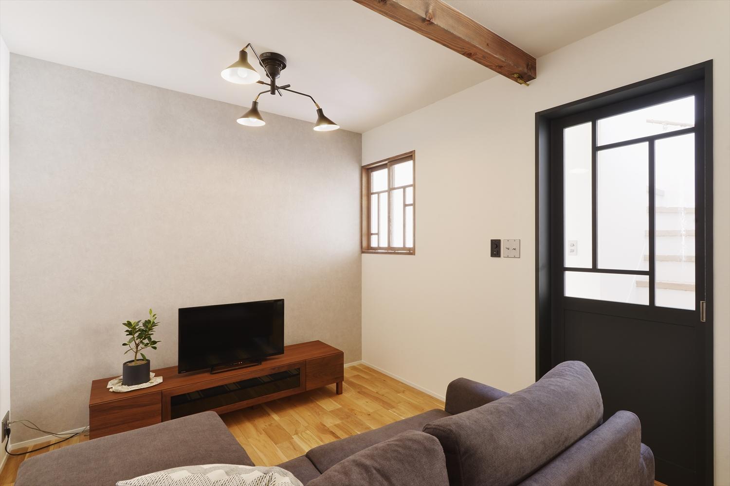 床はナラの無垢フローリング。壁の一面のみをグレーのアクセントクロスに。