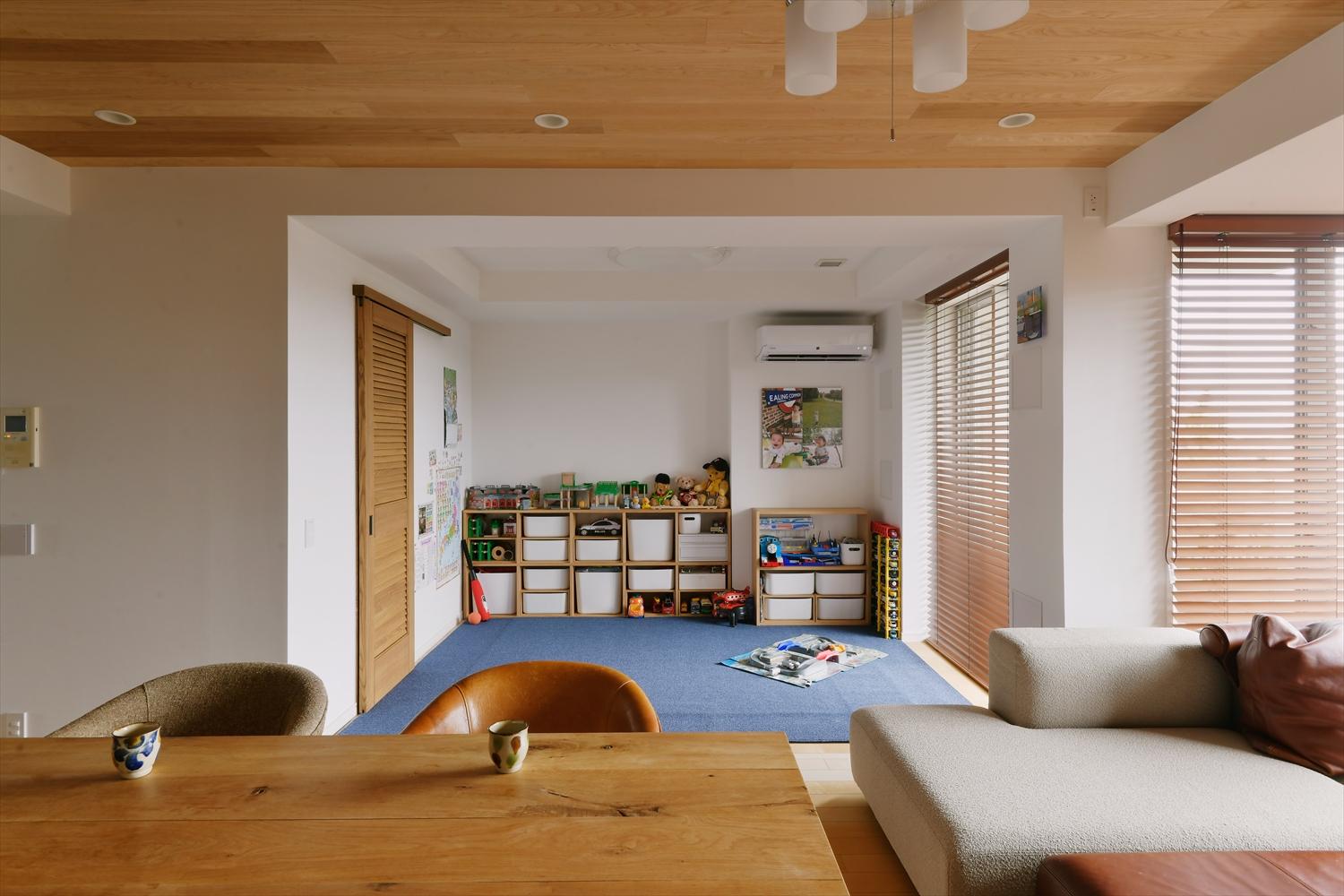間仕切りを撤去してリビングに取り込んだ洋室は、キッチンからも見守れるお子さんのプレイスペースに変身。将来、部屋が必要になったら再び仕切って個室に出来ることも想定。
