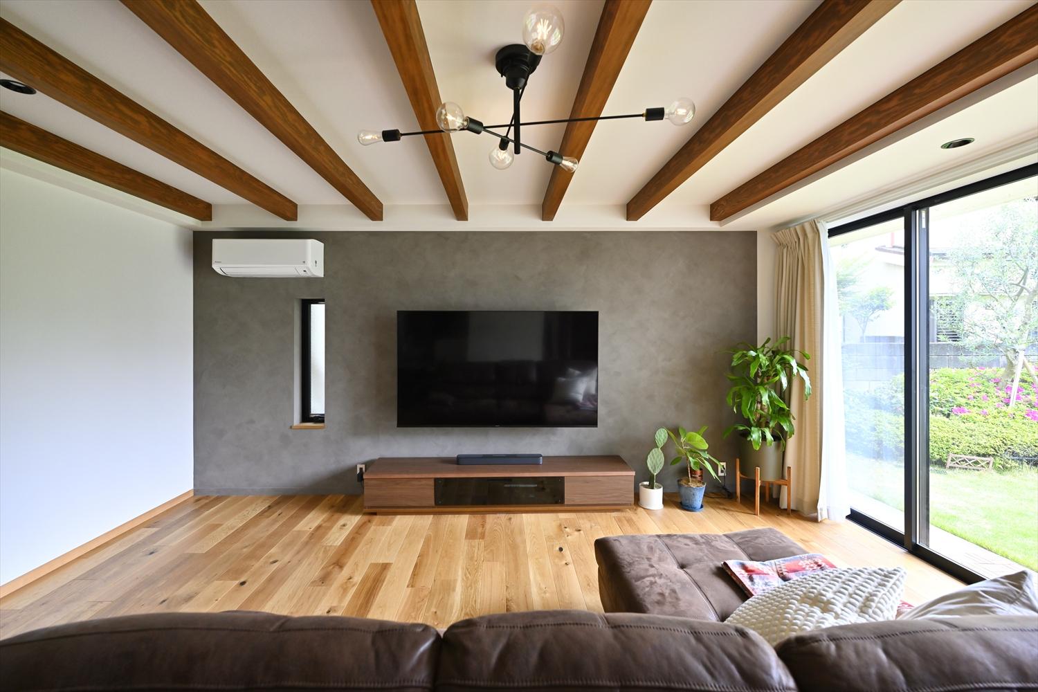 テレビは壁掛けにすることでスッキリと。グレーのアクセントクロスが空間にメリハリをもたらしています。