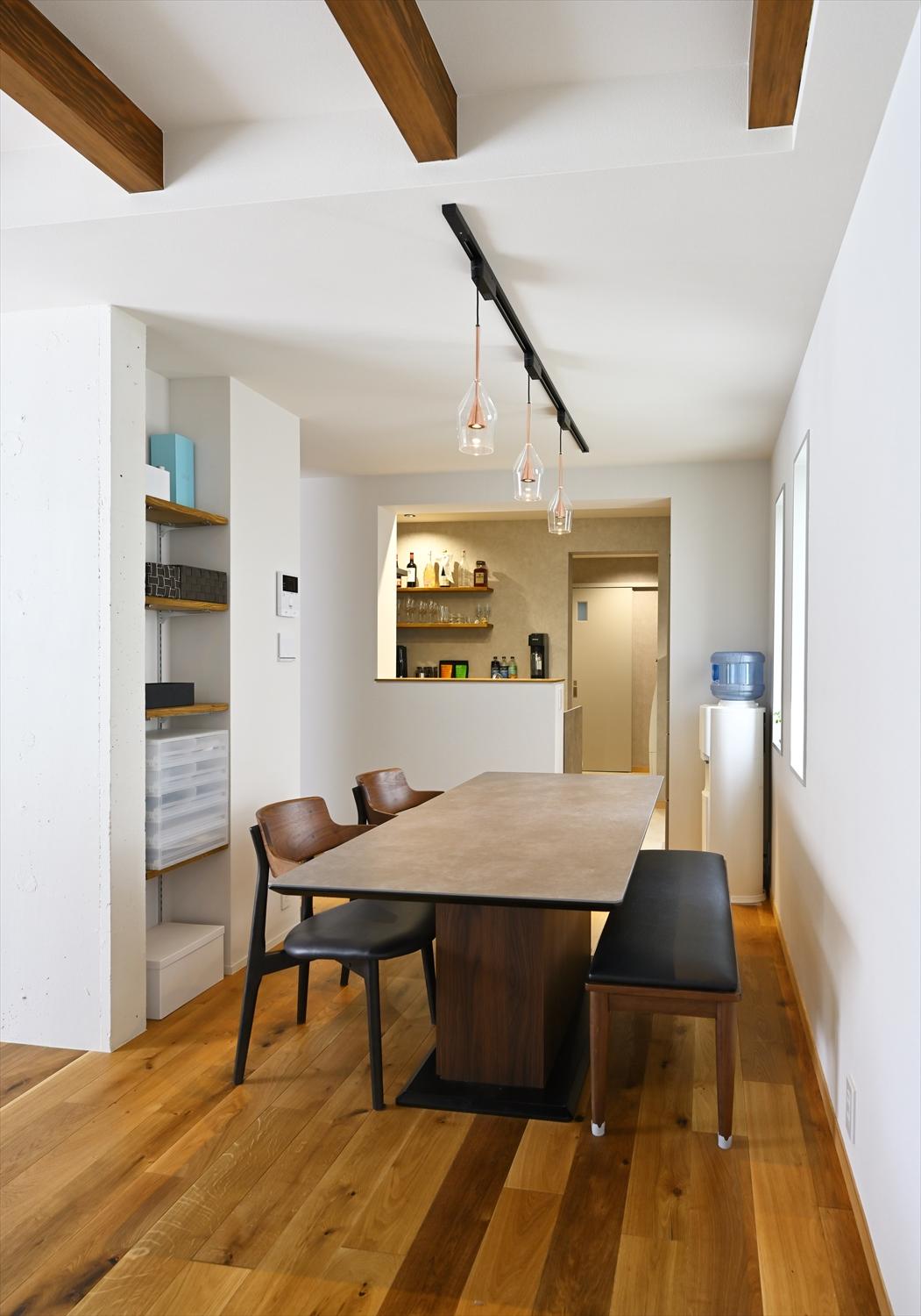 ダイニングスペース、既存の壁の一部を棚収納として活用。キッチン奥の入口からはユーティリティルームに回遊できるようになっています。