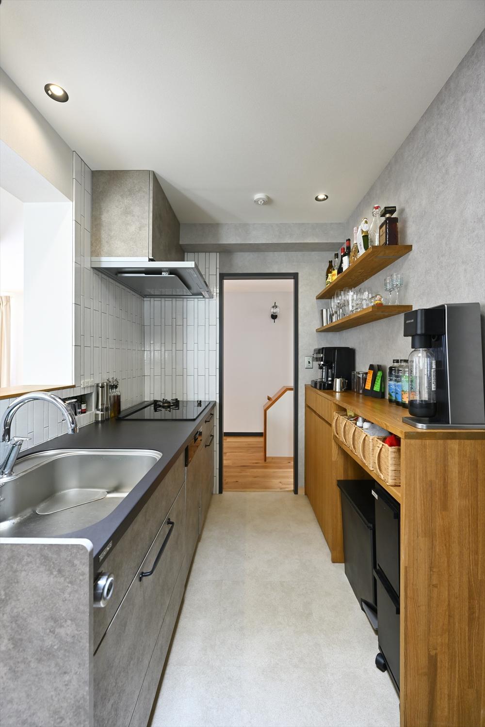 キッチンは対面式に。グレーのパネルと、壁面のタイル、フロアタイルを組み合わせました。