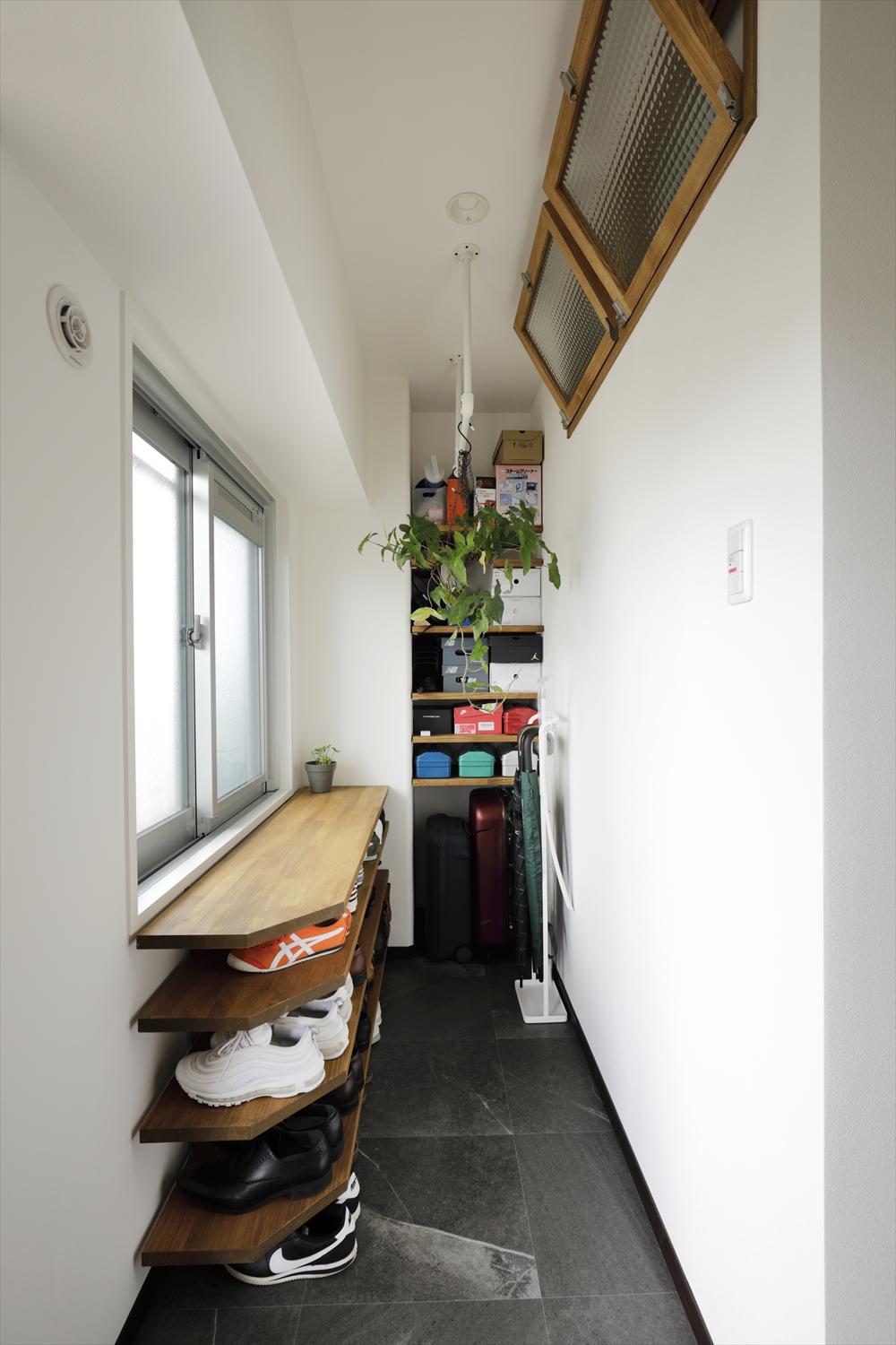 広めの玄関土間のSIC、ハンガーパイプに濡れたレインコートを干したりと便利に活用されています。上部の室内窓は寝室とつながっており、家全体に風がめぐるようになっています。