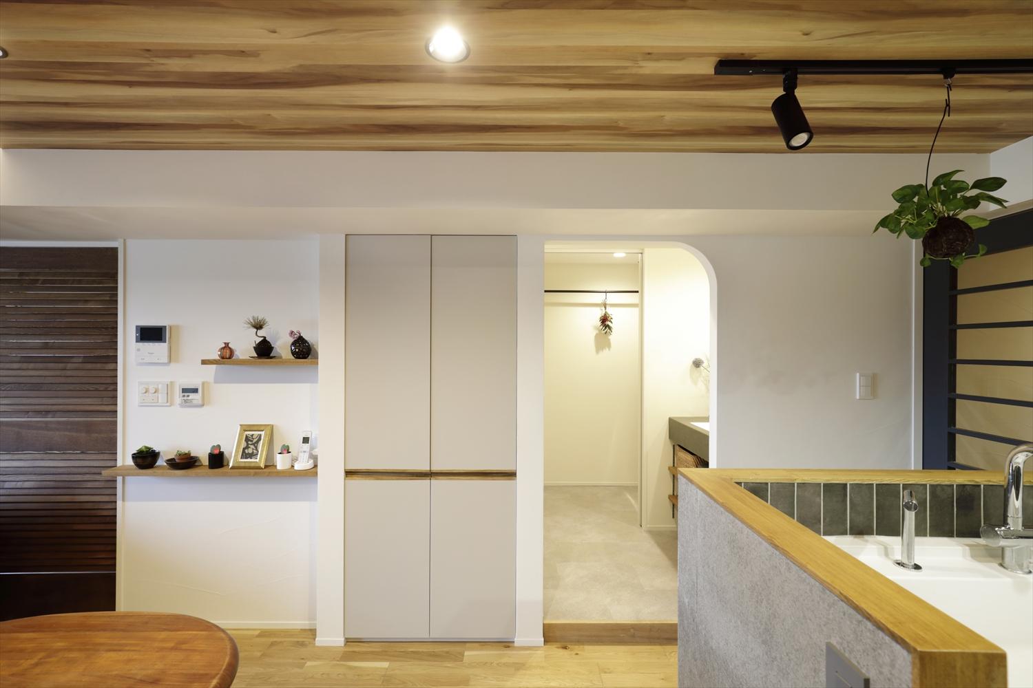 キッチンのすぐそばに洗面室の入り口があり、家事動線もスムーズ。片側だけアールのついた開口がアクセントになっている。