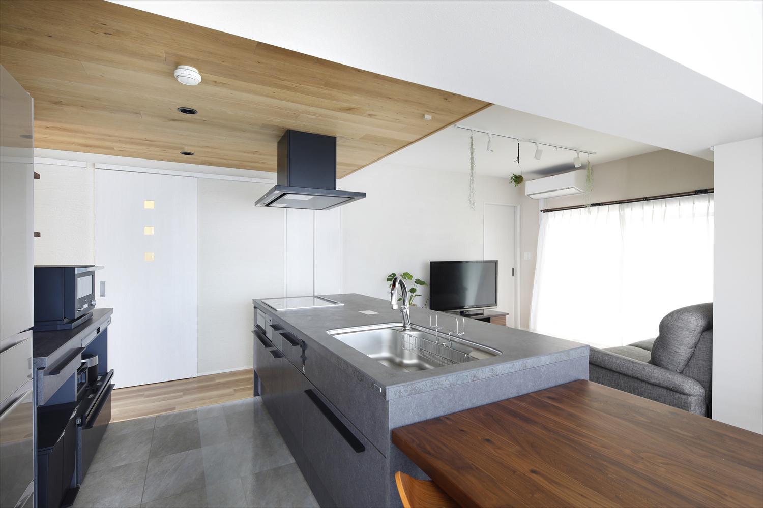 キッチンエリアは木目の折り下げ天井でゾーニングされています。天井に仕込まれた間接照明をつけると、LDK全体がやさしい雰囲気に。