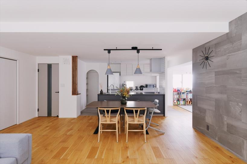 キッチン背面にはアール開口のパントリーも用意し、たっぷりとした容量の集約型収納で家事効率を高めています。「どこかに使いたい」と希望されていた木製格子をリビングドア横の腰壁に取り付け、シックな中にナチュラル感も。