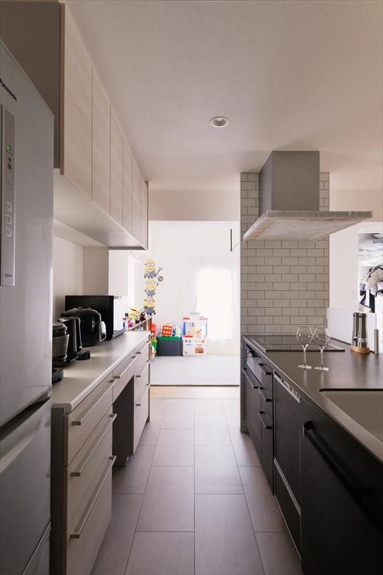 背面の収納やパントリーを活用することで、オープンなキッチンをいつでもスッキリとみせられます。画面奥のフリースペースで遊ぶお子さまの様子にも目が届きます。