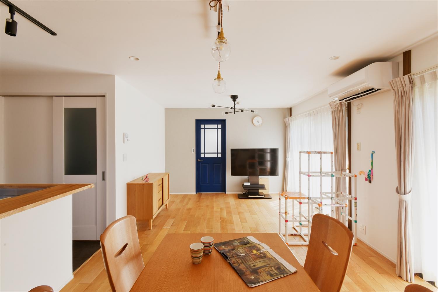 1階のLDKは既存の空間をそのまま活用。ベースカラーの白い壁にキリっとしたネイビーブルーのリビングドアがアクセント。