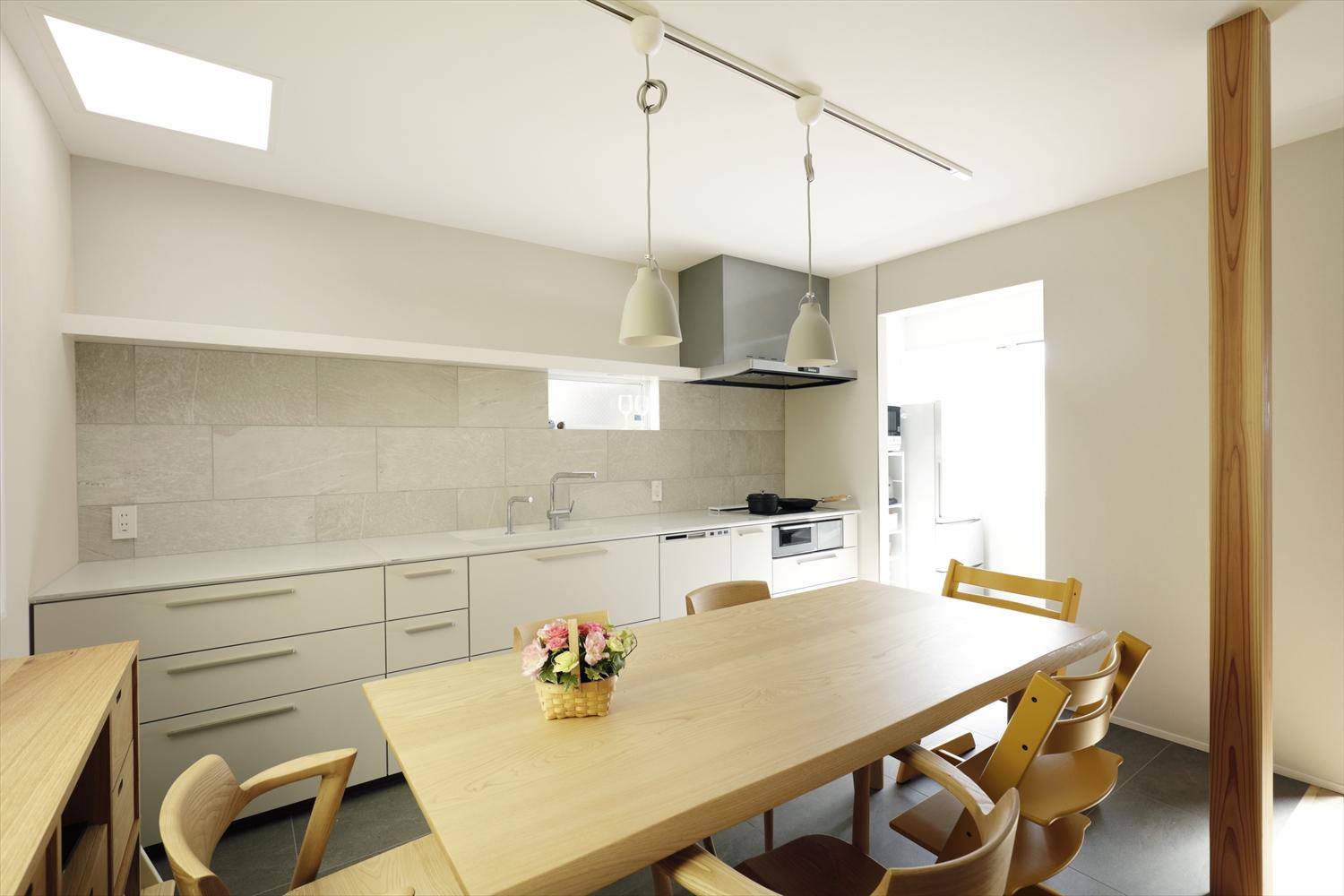 真っ白な壁付けタイプを設置し、既存のトップライトや壁面の窓を活用した、明るいキッチン。