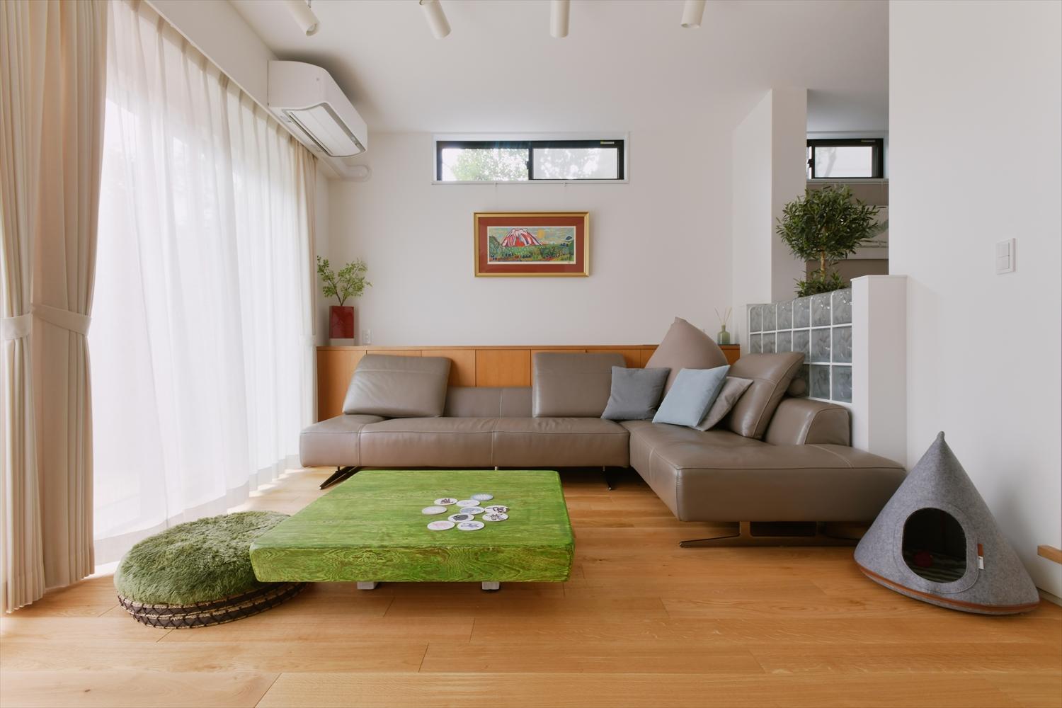 天井が高く、ゆったりとしたリビング。ダイニングとの境は、元々あった壁をガラスブロックの腰壁に置き換えることで空間に一体感が生まれ、またインテリアのアクセントになっています。