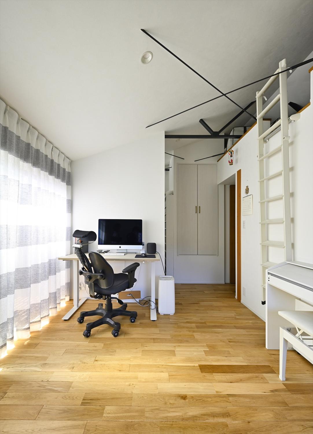 ２階ファミリールームにはワークスペースも配置。右手にはロフト。天井を上げることで広がりが生まれ、あらわしになった鉄筋は黒で塗装して空間のアクセントになりました。