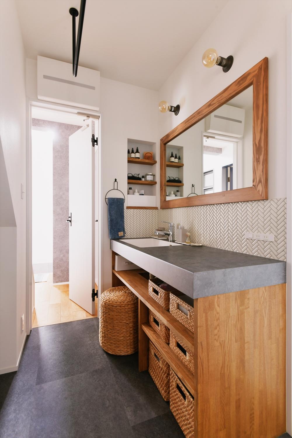 玄関の近くに位置する洗面台は、キッチンと素材感をそろえています。この洗面室を通り抜けて、玄関・キッチン間の移動ができて便利。