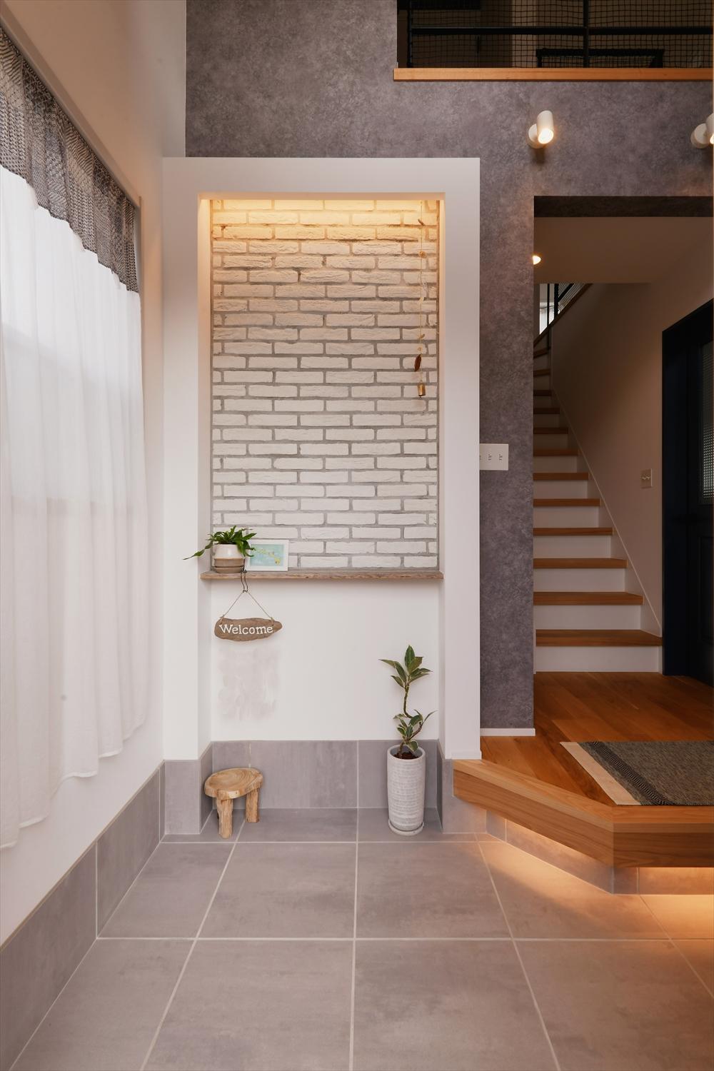 タイル張りのニッチと間接照明が、玄関のムードを演出します。