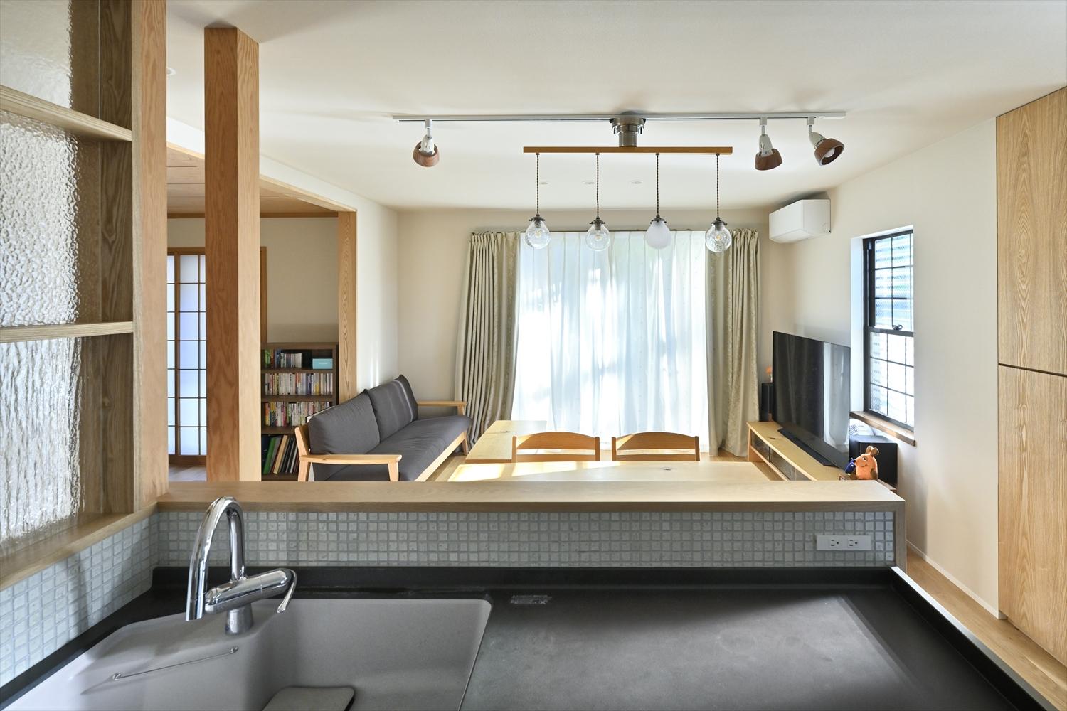 ダイニングと南側の掃き出し窓、さらに左手の洋室にも目が届く対面キッチン。