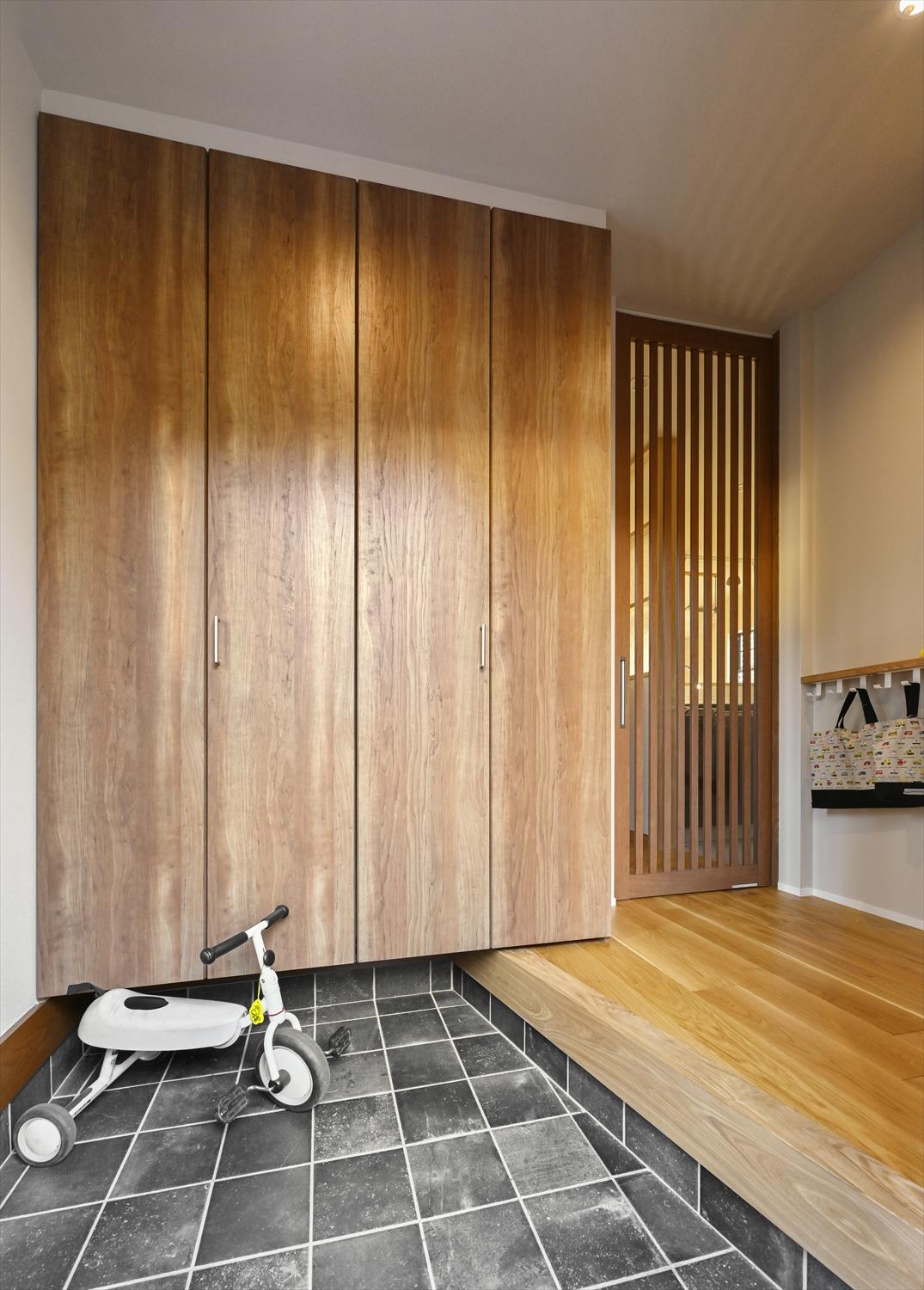 玄関の土間タイルや格子のリビングドアは、既存の建物が持つ和の要素に調和するものを選んで組み合わせました。リビングドアはペットの飛び出し防止にも役立っています。