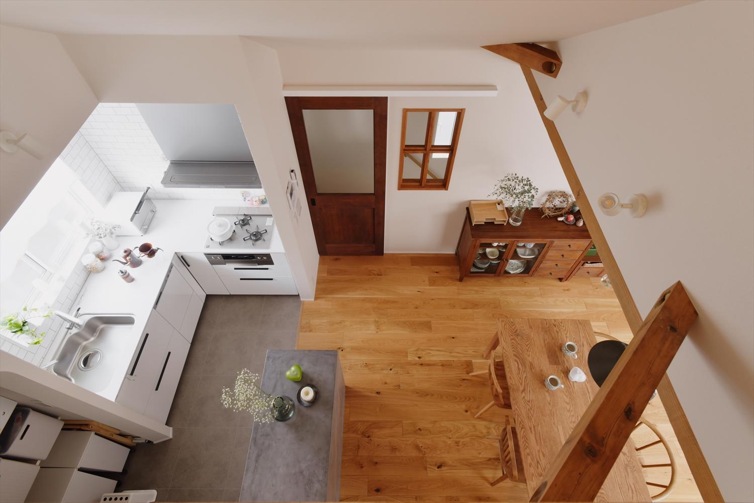 ロフトから眺めたLDK。白を基調とした空間に、LDはフローリング、キッチンはフロアタイルというように床材を使い分けて、お手入れもしやすく。