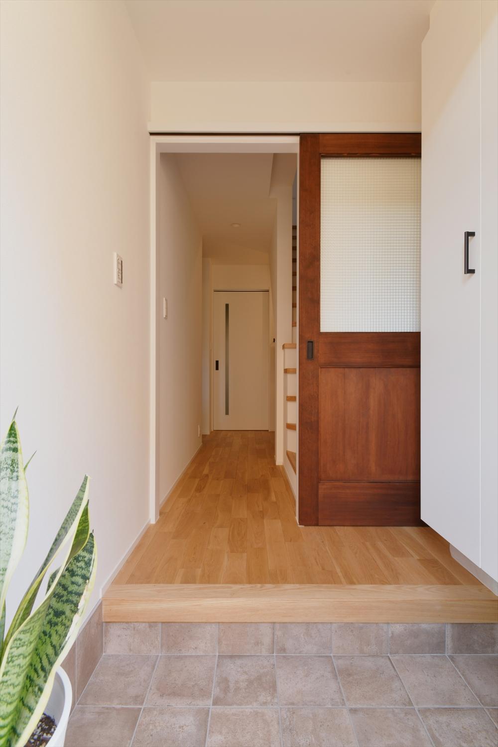 白い壁・石質のグレー・濃淡の木の色のコンビネーションは、玄関ともリンクしています。
