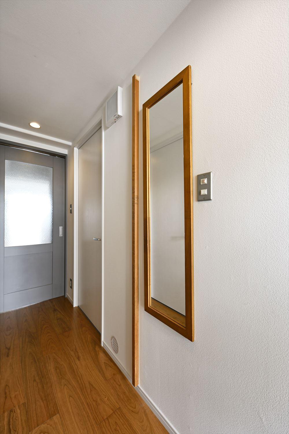 玄関ホールの姿見の横には、元々和室の引き戸枠に使われていた木材を取付。お子さんたちの身長を記録されていた木材が、このお家のシンボルとして引き継がれました。