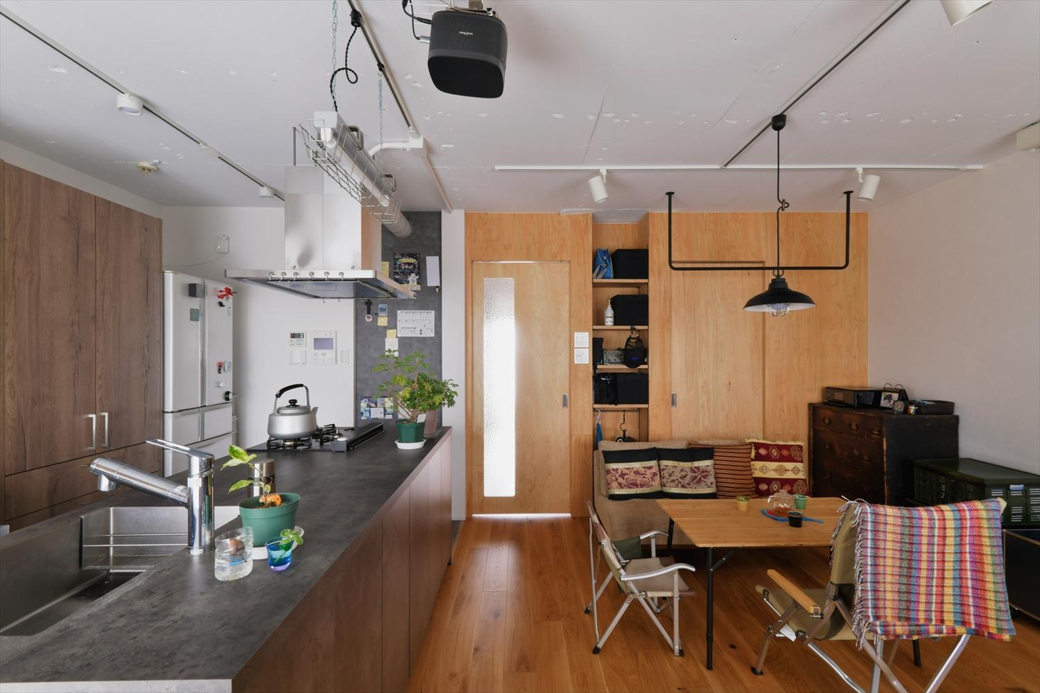 お気に入りのアンティーク家具やキャンプギアが似合うインテリアにするため、壁の一部は板張りに。建具もそれに合わせて一体感をだしました。天井はラフな躯体現しに。