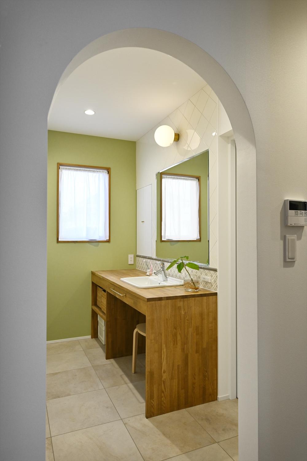 洗面室は、脱衣室と分けたことでいつでも気兼ねなく使えるように。木製のカウンターに、正面の壁面にはこだわり抜いて選んだタイルが四半目地に貼られ、側面の壁には優しいグリーンのアクセントクロス。どこからもアクセスしやすい位置にあるため、日常の手洗いもラクラク。