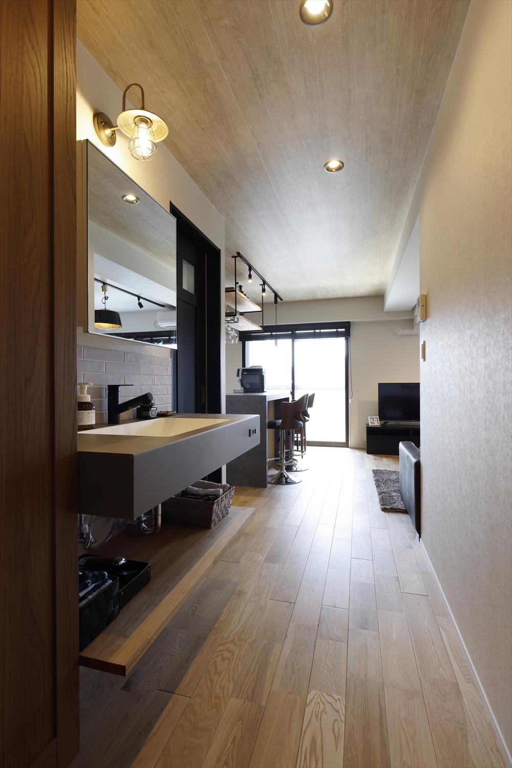 洗面所はあえて廊下に設けることで、居住空間や脱衣室のスペースを圧迫することなく、コンパクトながらゆとりのある空間となりました。玄関を開けるとすぐに目に入る位置のため、洗面台はもちろんのこと、ミラー収納や照明のデザインにもこだわりました。