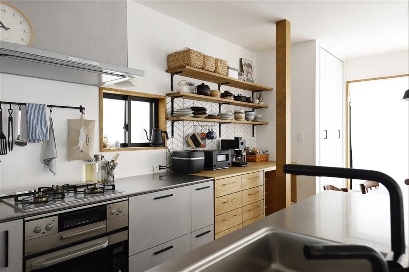 キッチン背面には家電やゴミ箱を置ける収納を設けました。オープン棚に並んだ食器や鍋もインテリアのアクセントに。