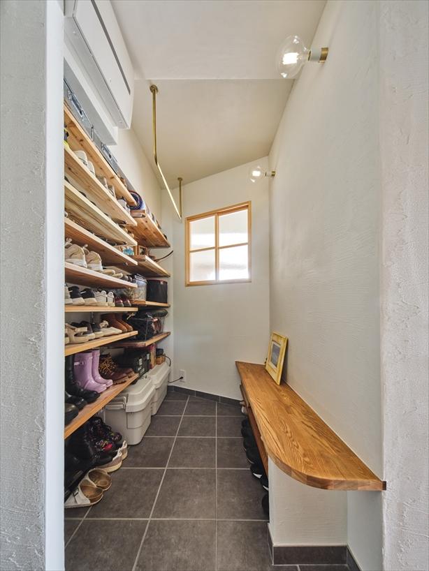 玄関収納は広々と使える土間スタイルに。オープンな靴棚のほかにベンチも設け、靴を履いたり荷物を一時置きしたりと多目的に使えるようにしました。