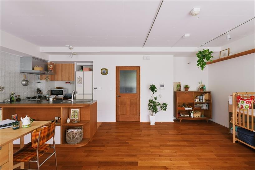 LDKの床にはナラの無垢材を採用。キッチンやリビングドアなどの木部も、お気に入りのチェストと色調を合わせ、やわらかな木の雰囲気で統一しました。壁面いっぱいに設けた飾り棚はアクセントとなり、好きなアイテムやグリーンを楽しめます。