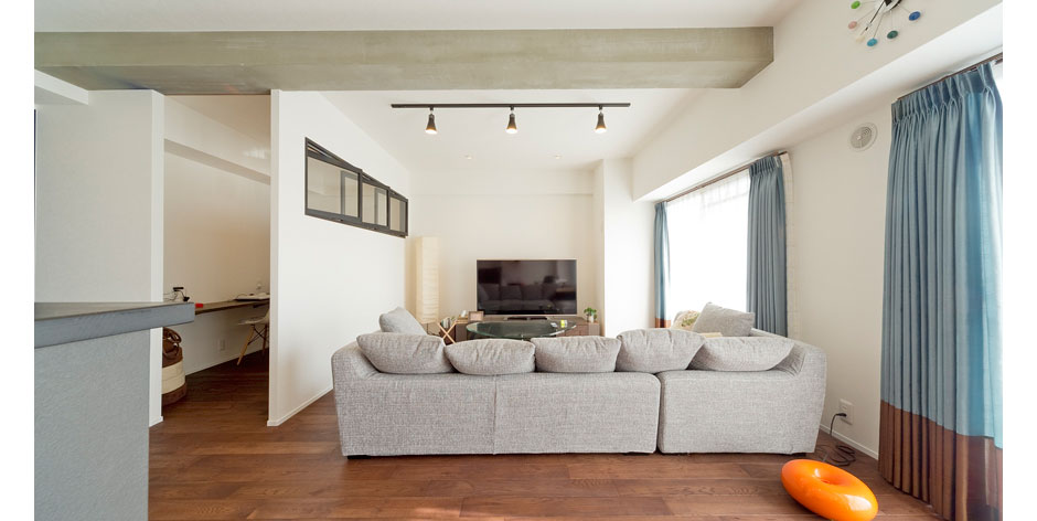 平凡な3LDKの間取りを2LDKに変更。18帖あるLDKにはカラー塗装した無垢のドアや黒枠の回転窓、モルタル塗装の梁などが絶妙にまとまり、シンプル＆クールな空間になりました。