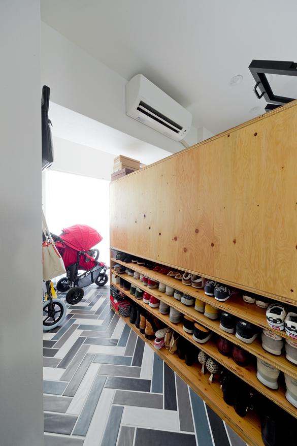 玄関裏にはご夫婦の趣味スペースが。靴収納で間仕切り、床をカラフルなヘリンボーンタイル張りにしました。靴がオープンに見えているのも、床の色を相まってごちゃついて見えないアイデアです。