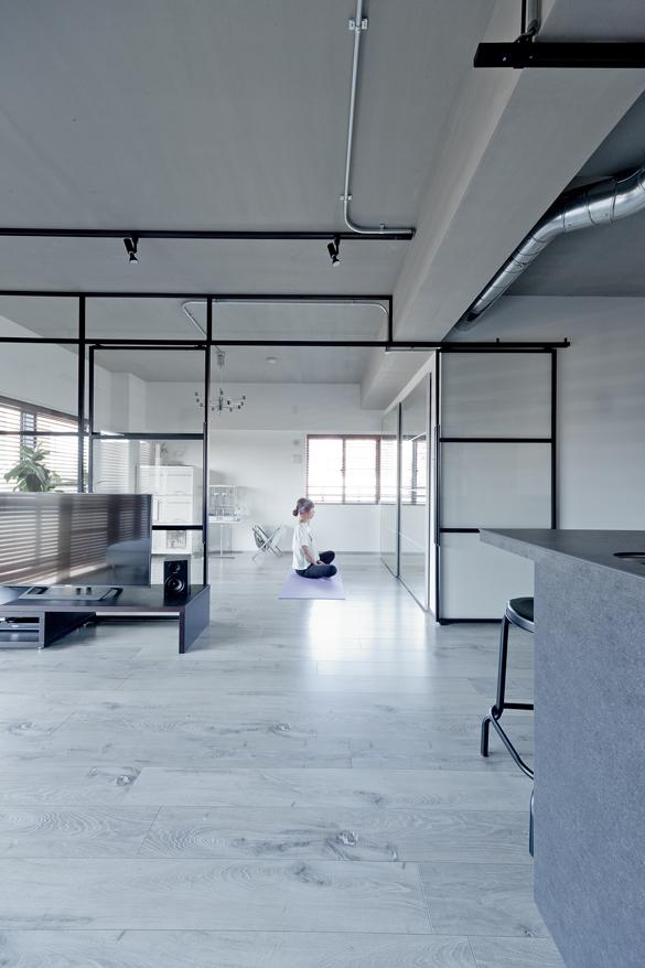 リビング奥のガラスで間仕切られた空間は趣味室のトレーニングルーム。旦那様は筋力トレーニングに、奥様はヨガを楽しむ空間として使用。収納クローゼットの扉には鏡を採用しました。