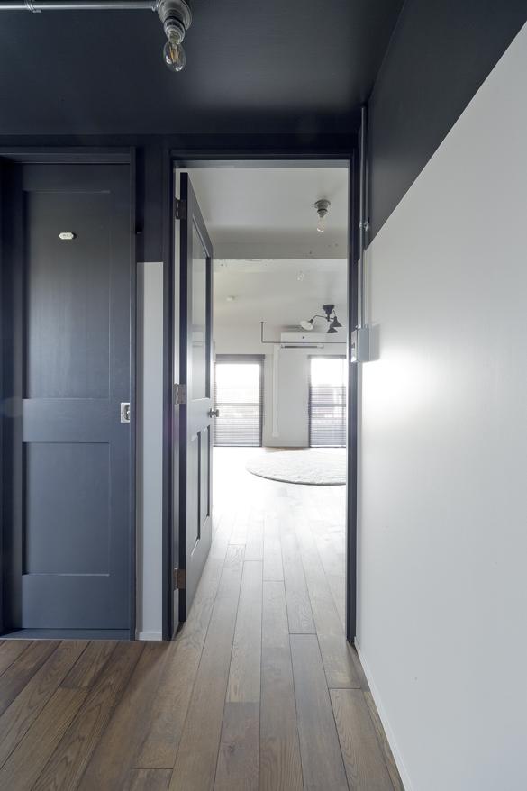 廊下ホールからリビングを見ると・・・区切られたブルーグレーとホワイトがとても気持ち良い光景が目に留まります。オークの無垢フローリングも濃いブラック調に色が入り、モダンな雰囲気と木の持つ優しさとが見事に調和しています。