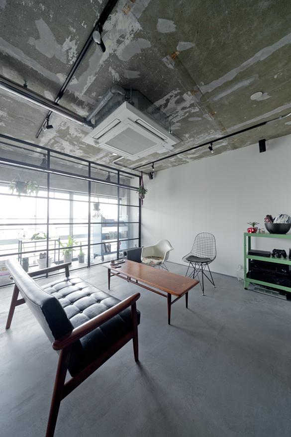 窓際のインナーテラスが印象的なリビング。テレビはプロジェクターで映し出すなどして生活感の少ないシンプルな空間に。カフェの一角そのものです。