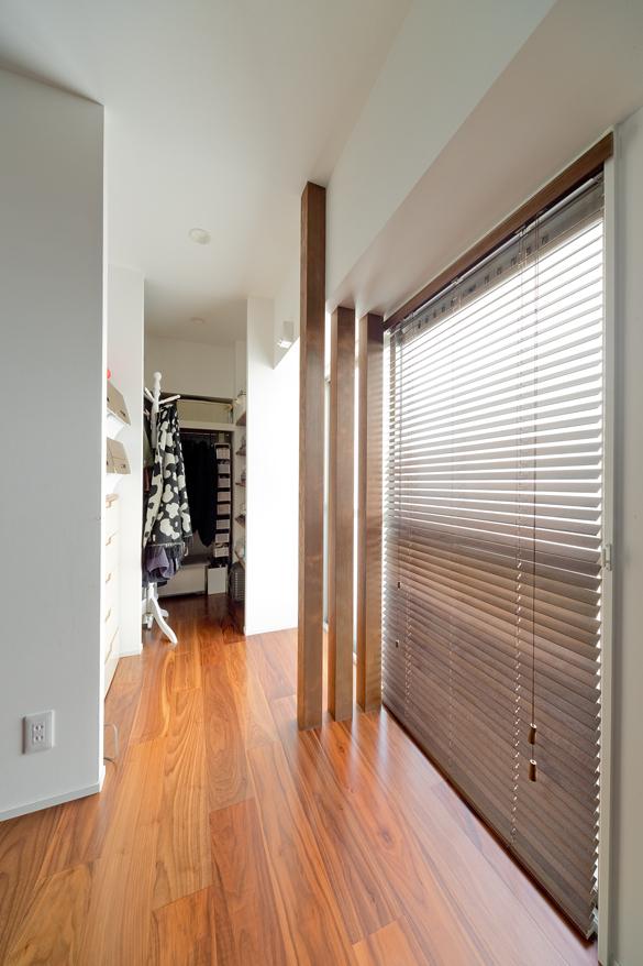 クローゼットはセミオープンで、床の質感に合わせたルーバー柱を取り入れました。クローゼット前の空間は洗濯ピットを取り付けて、雨の日には洗濯スペースに早変わり。