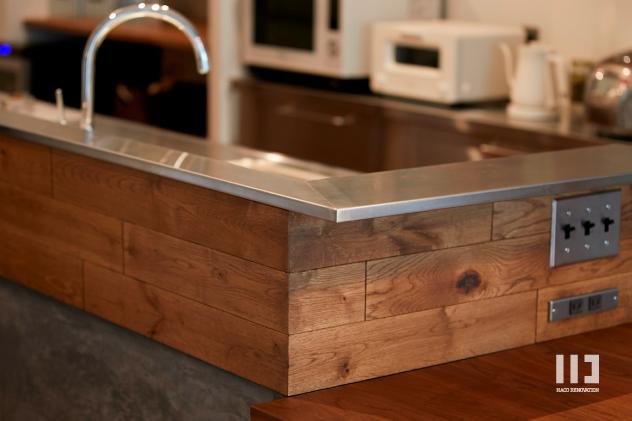 キッチンの周りの腰壁は墨モルタルとオークの無垢材で。