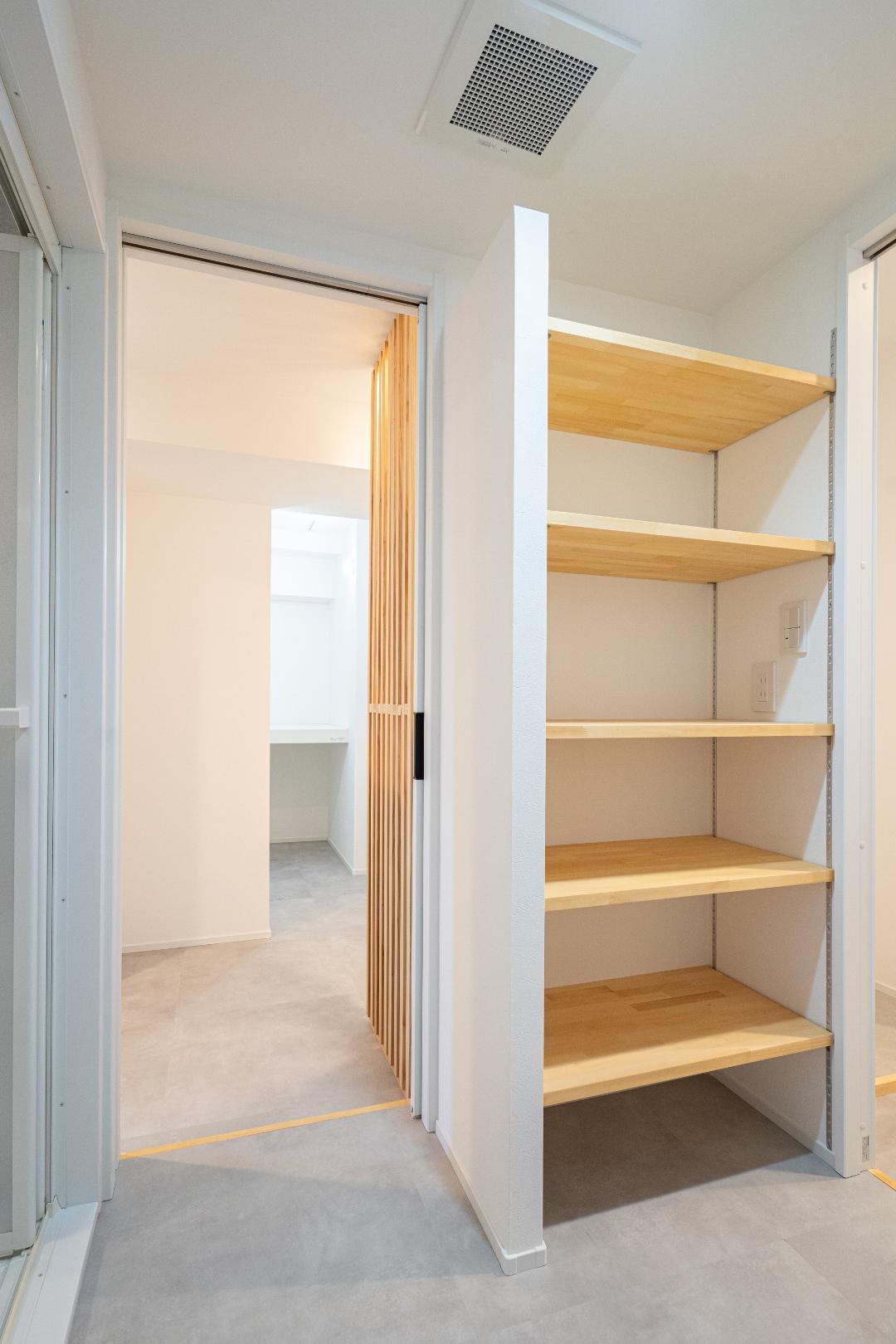 開放的なリビング・ダイニングとは反対に、ごちゃつきがちなランドリールームは引き戸で区切りました。また、小さな隙間にも棚を造作。棚の一角にコンセントを配置し、使い勝手よく仕上げています。