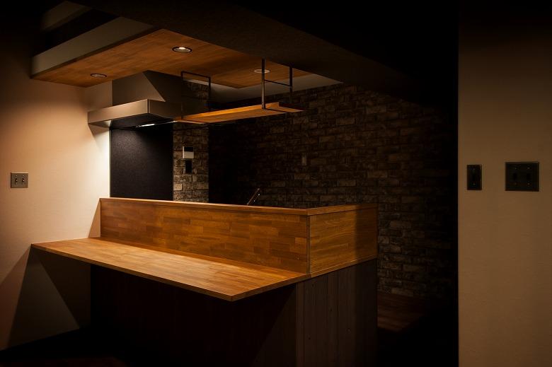 食事をとったり、お酒を飲んだり…。バー感覚で楽しめるキッチンを造作しました。
カウンタ上部には調光付きダウンライトでシーンにあった演出を楽しめます。