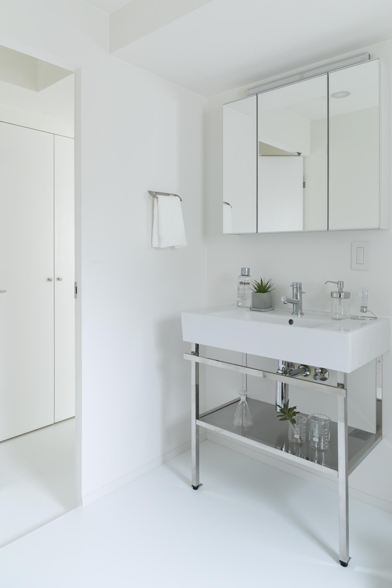 窓のある洗面室には、ステンレス脚の洗面台が存在感を放ちます。