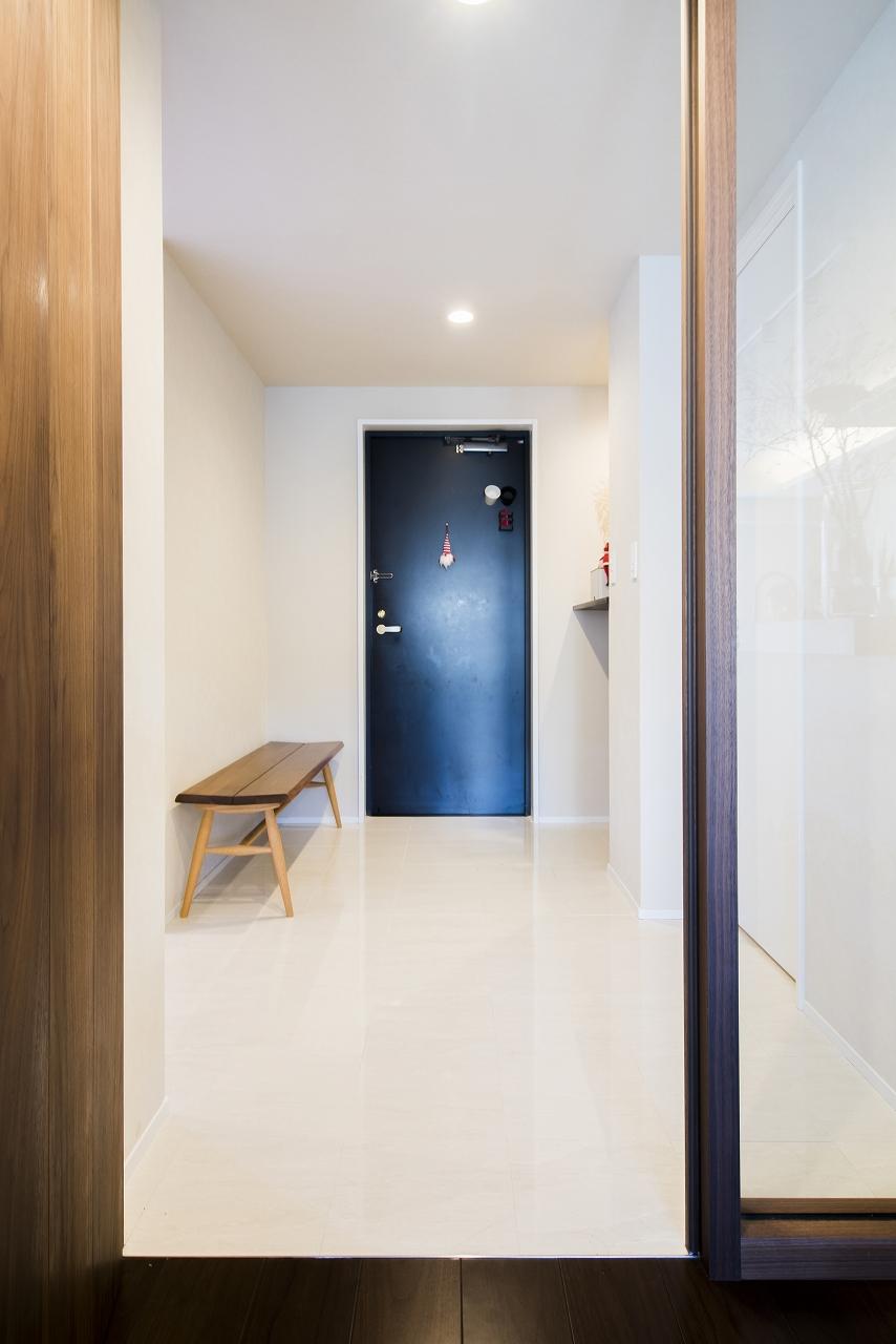 ベビーカーの出し入れがしやすいように、元々ついていた下駄箱を外し玄関を広くしました。玄関から廊下の床は大理石。リビングは木のフローリングです。元々はオールカーペットの家だったとのことですが、大理石は洗面所、トイレまで貼ってつながりをつけています。