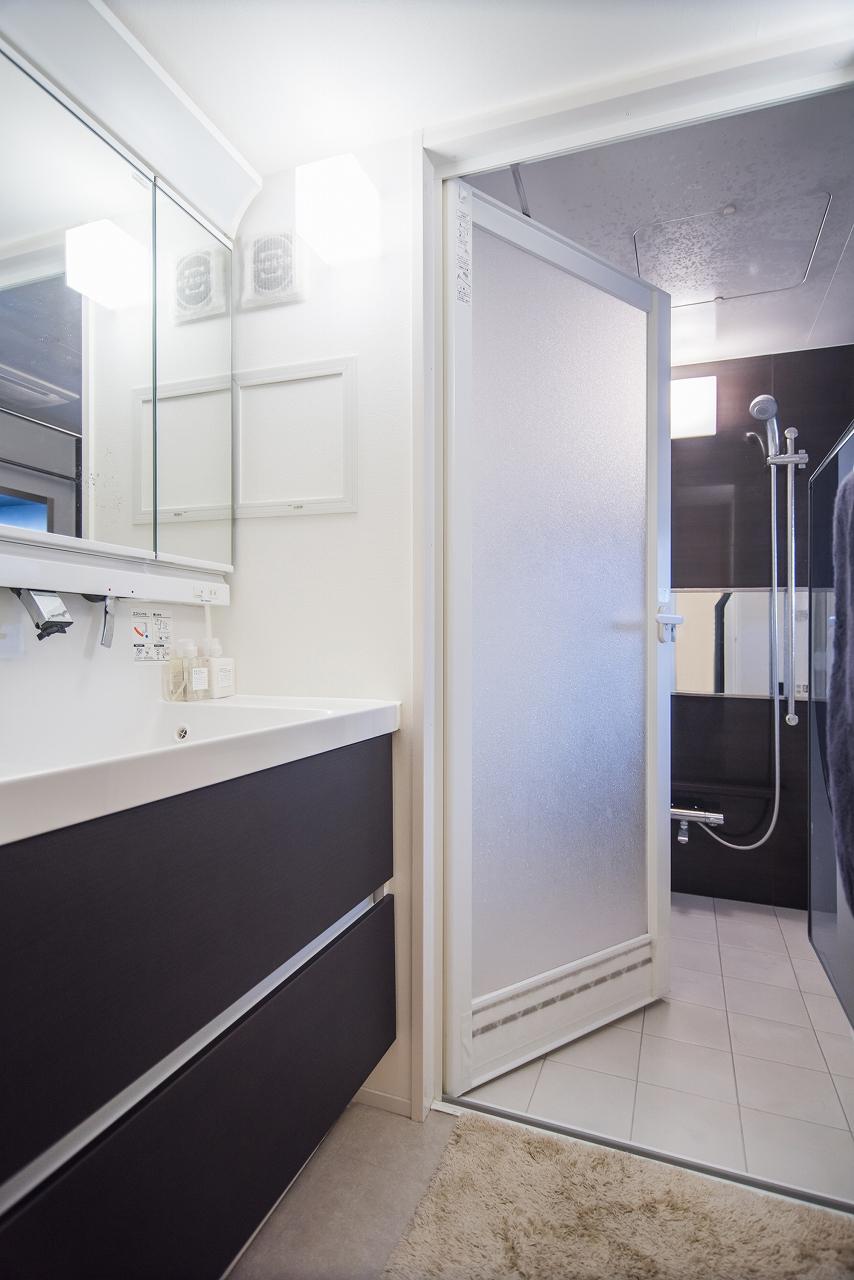 落ち着いたブラウンがアクセントカラーの、清潔感ある洗面室とバスルーム。