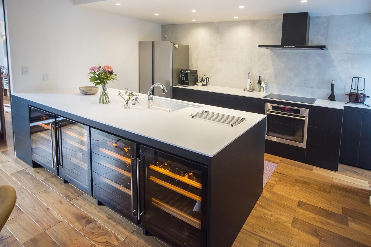 オリジナルで作ったキッチンです。吊戸棚は一切設けずに、収納はすべてカウンターの下に設置しています。キッチンカウンターはかなり広い天板で、ワインセラーは4台すっぽり入るように特注しました。