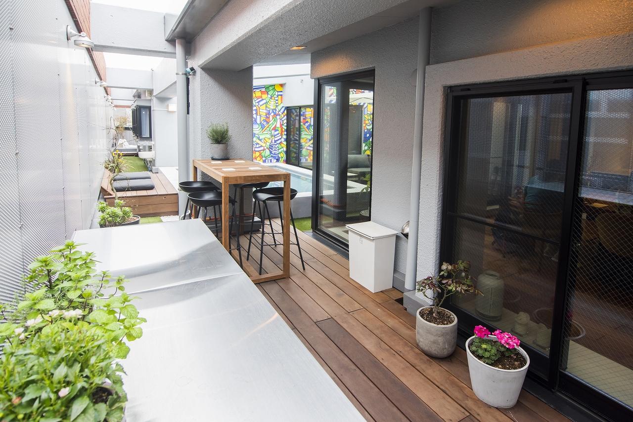 キッチン側から寝室側までグルっと回遊できるテラスには、人工芝が敷かれていたり、タイル石をディスプレイしてあります。さらに、バーベキュー用のグリルも置かれ、外で食事ができるテーブルも設置されているのですが、これらはすべてY様とA様の手作りによるものです。