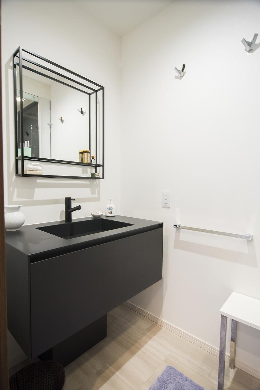 幅広めの洗面化粧台の後ろには、こちらは黒を基調としたシックなデザインの洗面化粧台を設置しています。