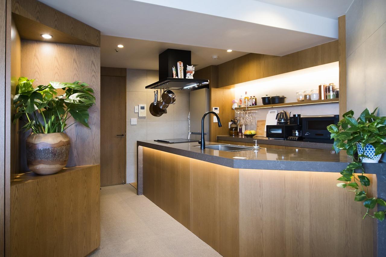 キッチンの棚にも間接照明が設けられていて、並んでいるお酒やキッチンツールに、柔らかな光が当たってとても良い雰囲気です。加えて、引き出し収納には、ゴミ袋などを収納するスペースも設けられており、効率よく使える工夫がたくさん取り入れられています。